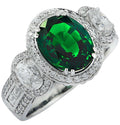 Vivid Diamonds 3.38Ct Oval Cut Tsavorite & Diamond Halo Ring in 18K White Gold featuring a vibrant green Tsavorite centerpiece surrounded by sparkling diamonds, exuding luxury.